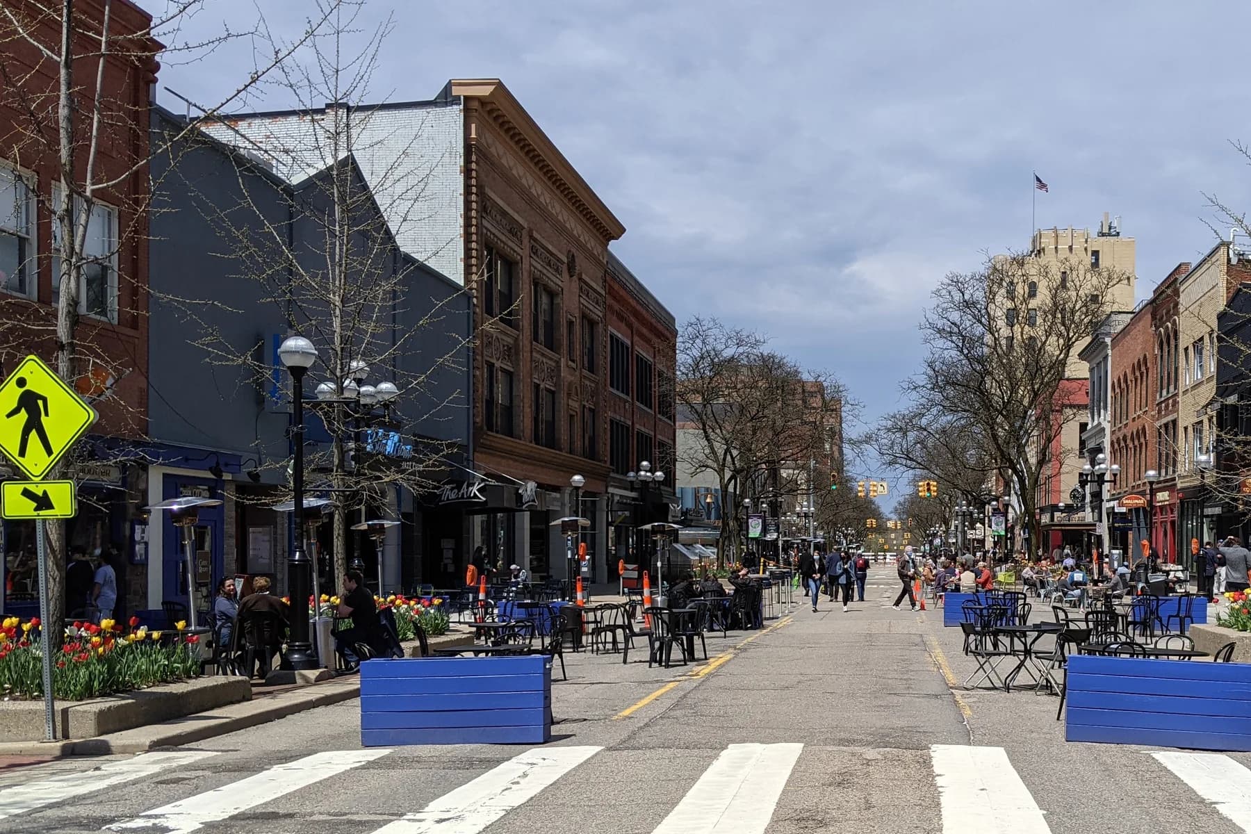Pedestrians, cafes, and historic storefronts along Main Street in Ann Arbor.