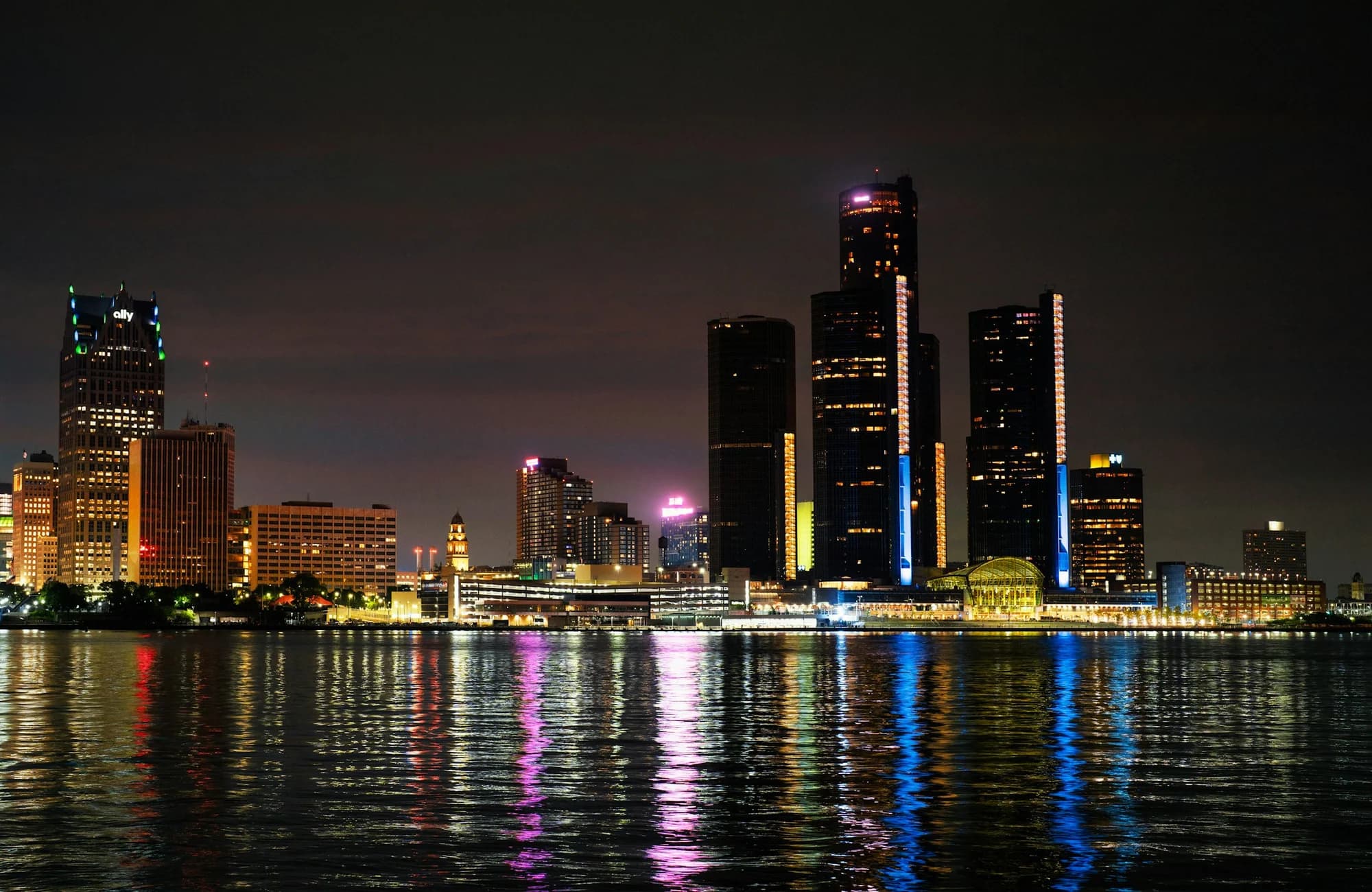 The Detroit skyline reflected across the river at night.