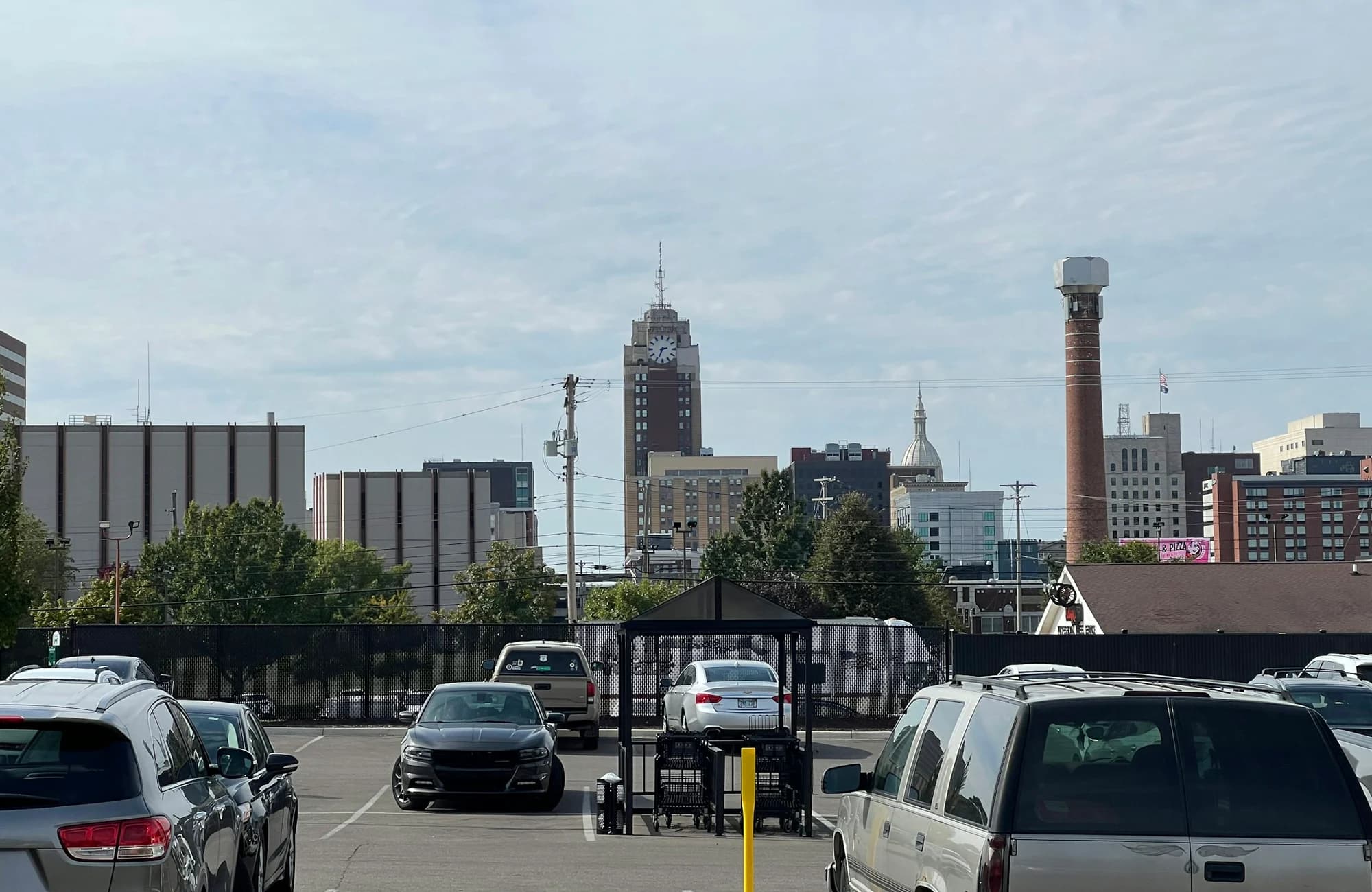The downtown Lansing skyline seen across a city parking area.