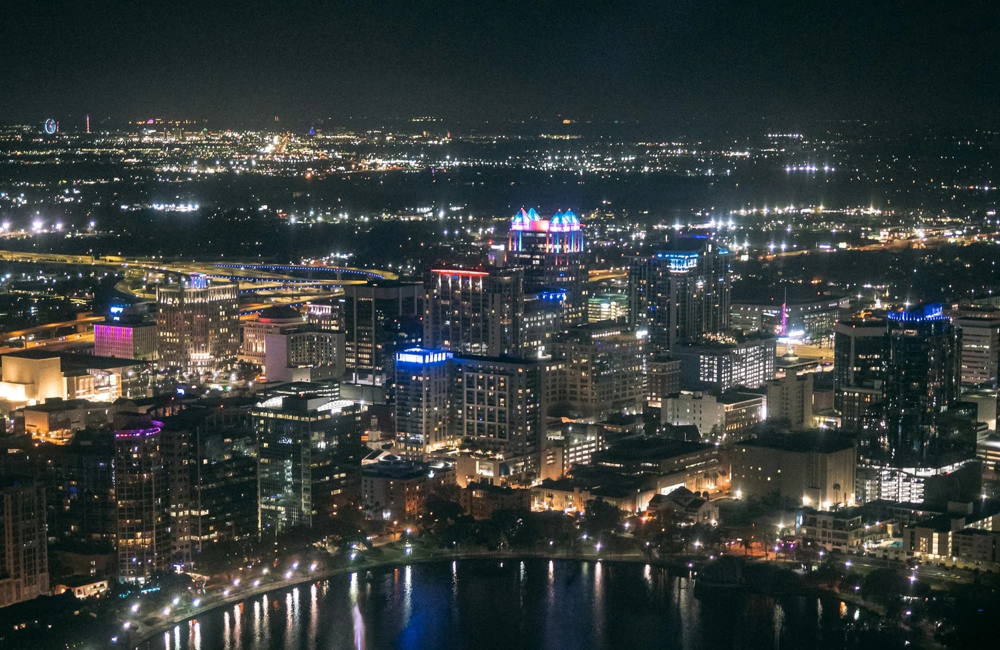 Downtown Orlando reflected across a lake at night.