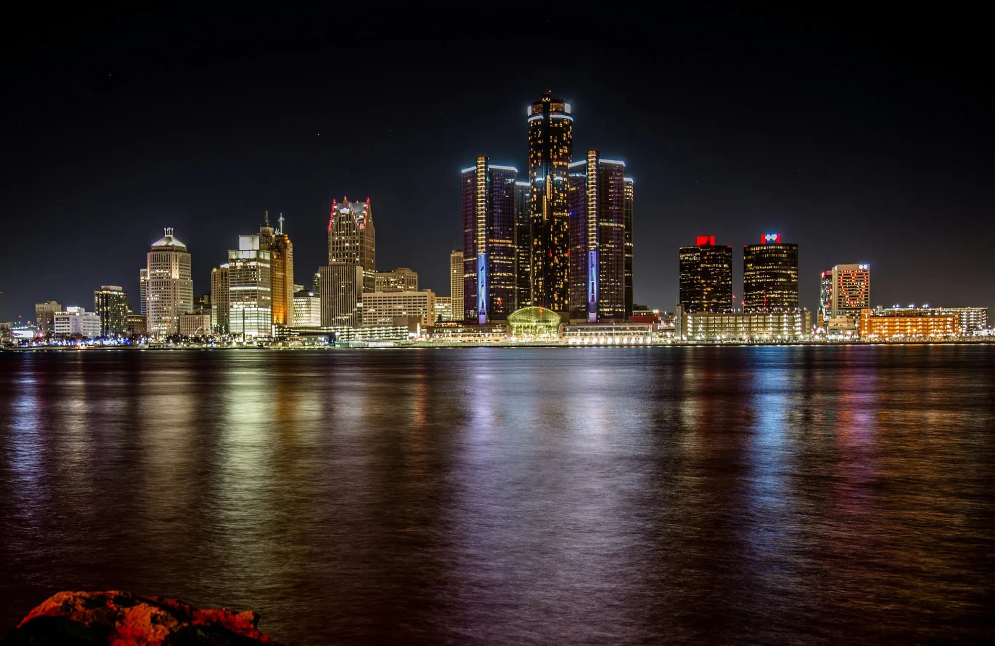 The Detroit skyline illuminated across the river at night.