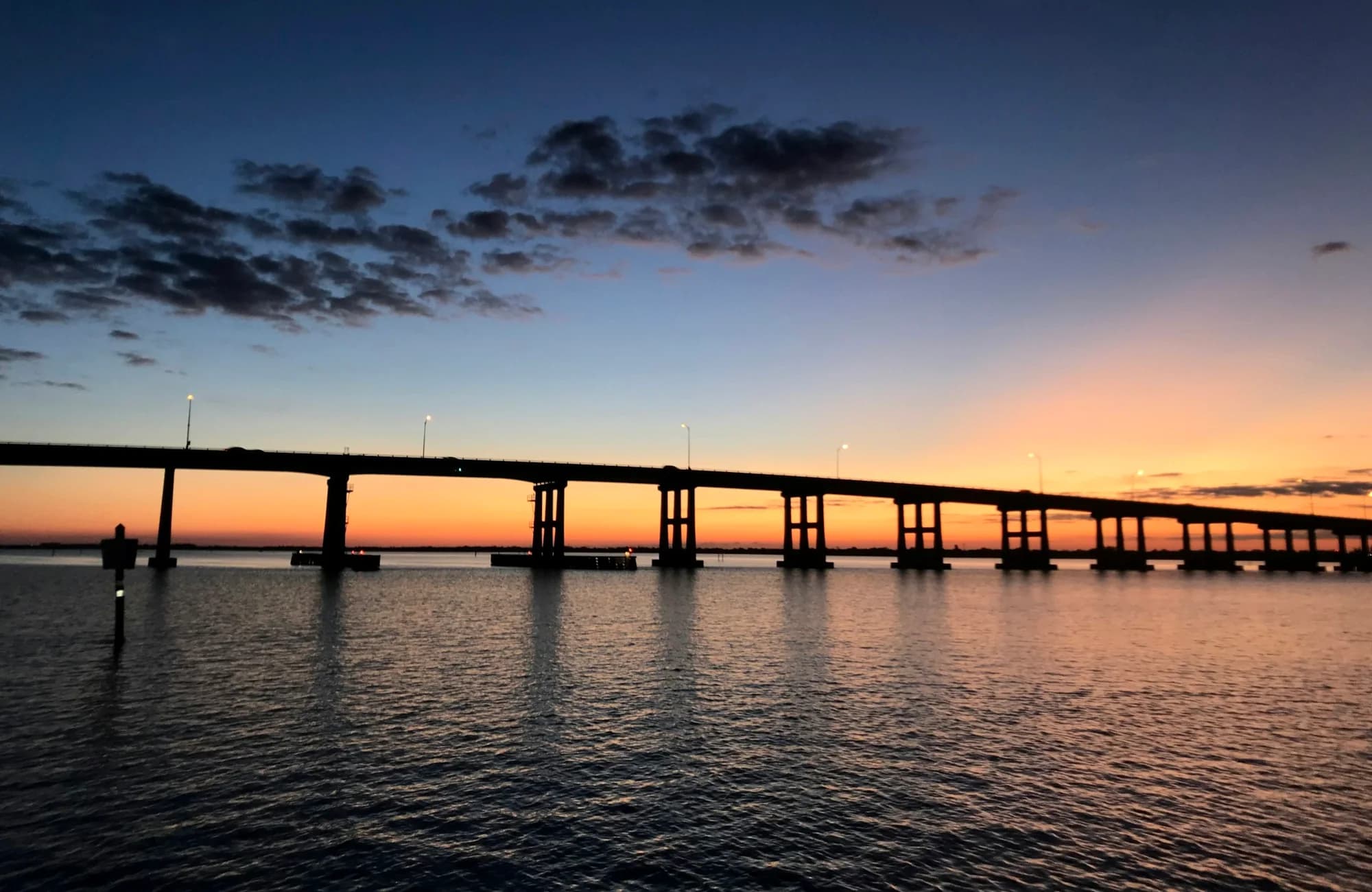 A Fort Myers bridge crossing the Caloosahatchee River at sunset.