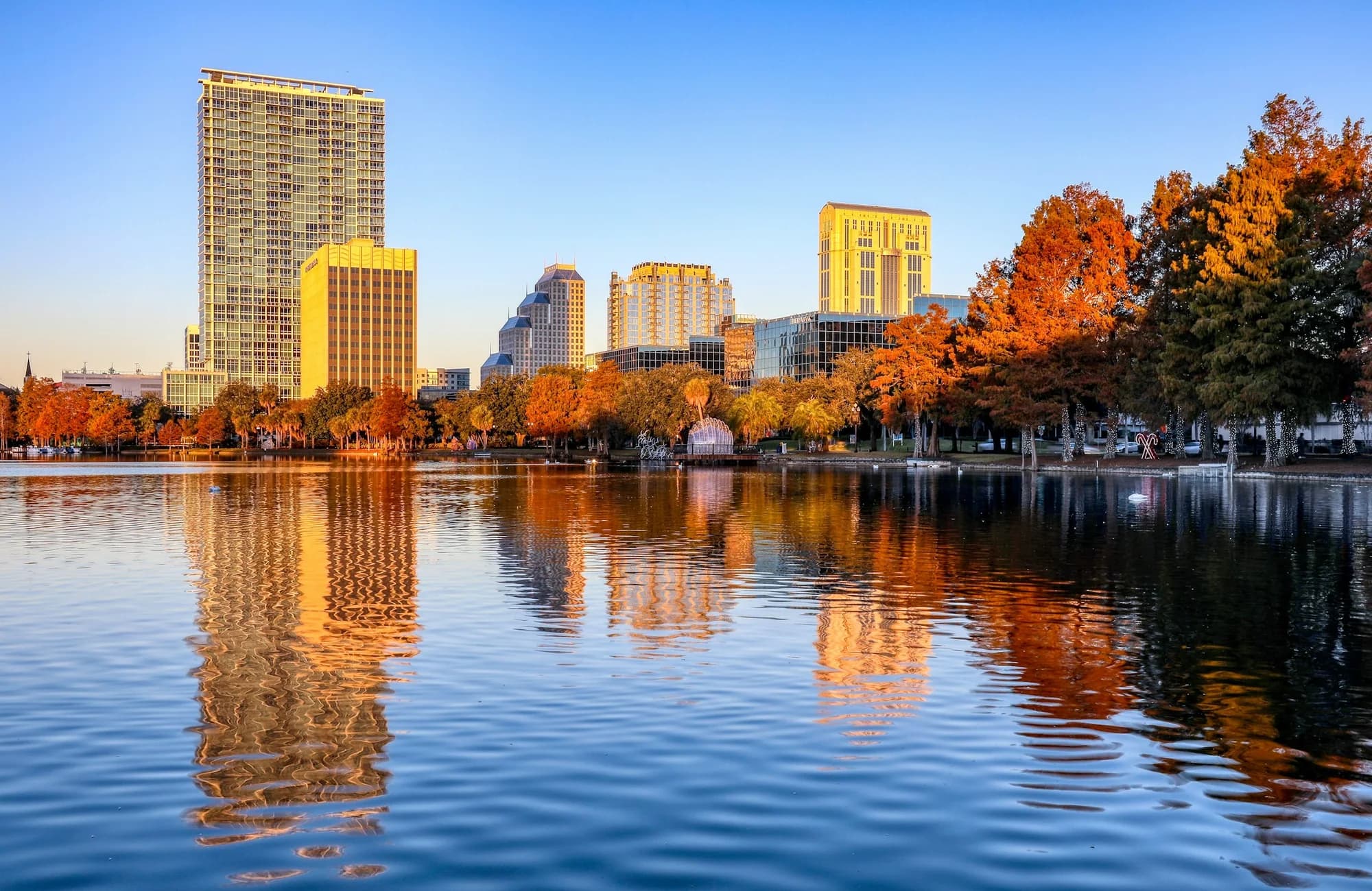 Lake Eola framed by trees with downtown Orlando beyond it.