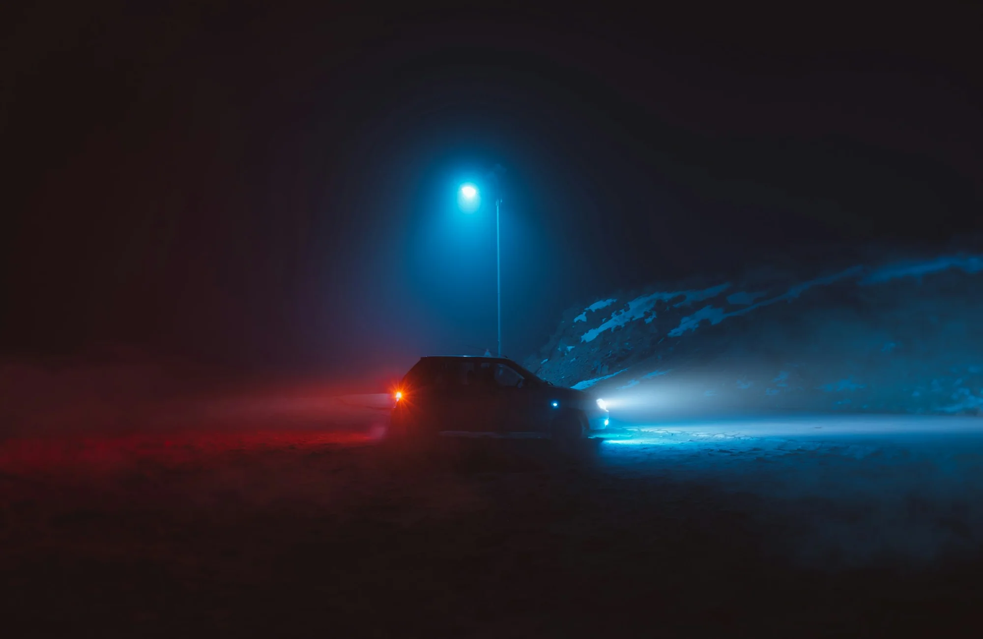 A car traveling along a dark roadway at night.